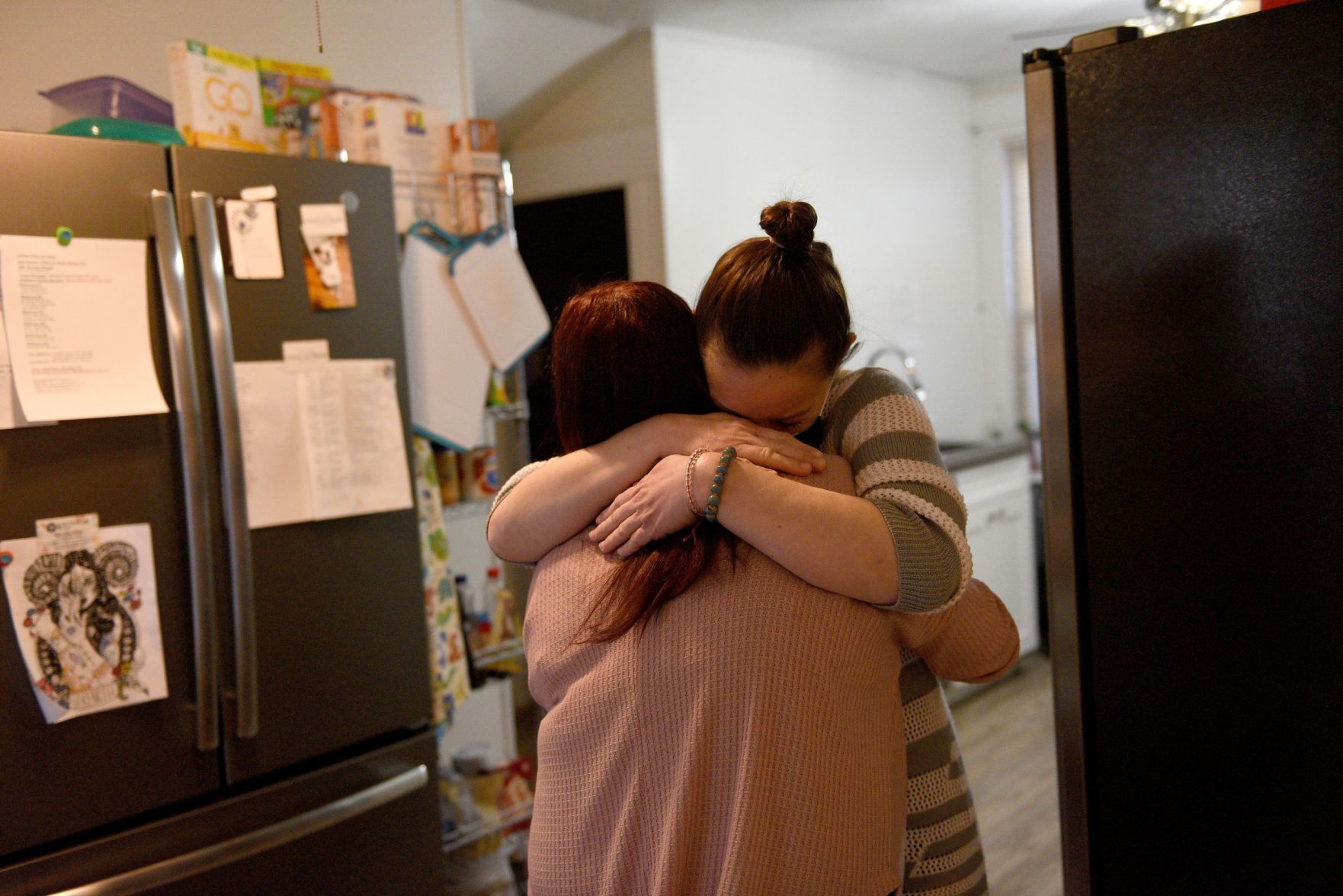 Sober house residents hug